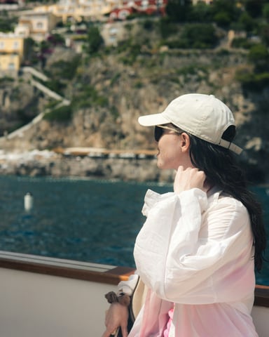 Woman relaxing on a boat with coastal town behind