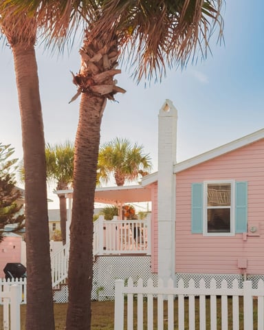 Pink coastal cottage with palm trees